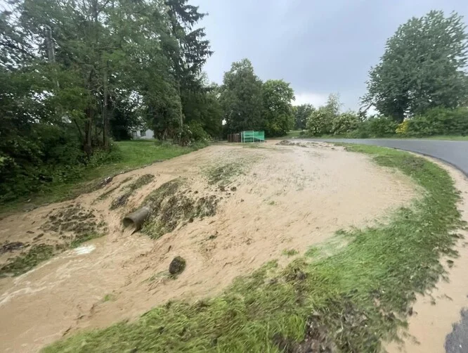 Zničená půda u silnice způsobená vodní erozí.